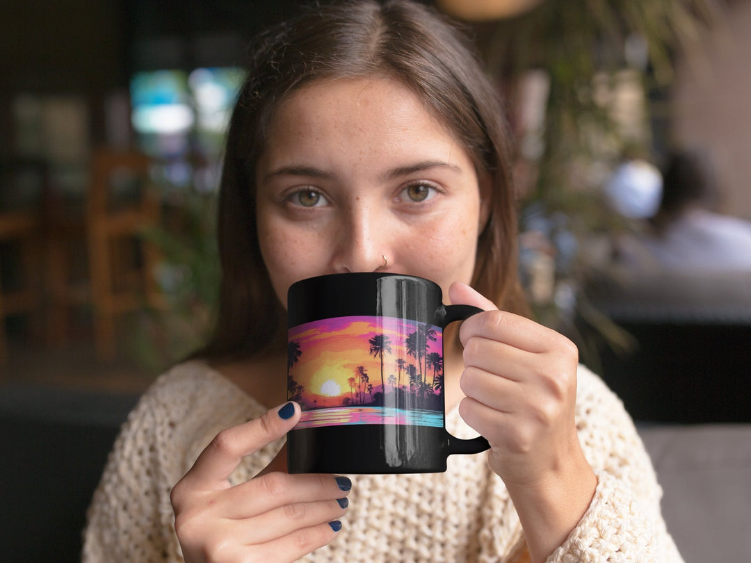 woman drinking from black mug with sunset beach design